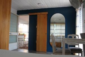 a room with a blue wall with a table and a mirror at Casa Benelaa in Oaxaca City