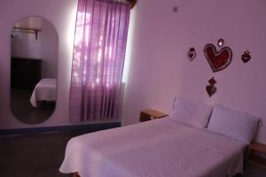 a bedroom with a white bed and a mirror at Casa Benelaa in Oaxaca City