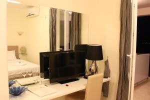 a room with a desk with a television and a bed at Swiss Residence Montenegro in Herceg-Novi