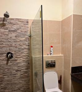a bathroom with a toilet and a shower at Golden Sun in Diani Beach