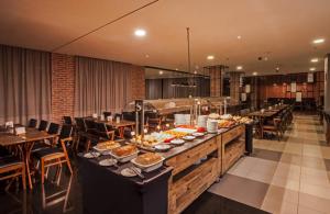 a buffet line in a restaurant with food on it at Flat de Luxo Aeroporto Congonhas - Hotel in São Paulo