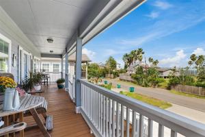 a porch with a table and a bench on a house at Portofino House - Seabrook - 3 Bed 2 Bath Hot Tub in Seabrook