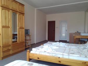 a bedroom with a large bed and a wooden cabinet at Guest House Diamant in Sozopol