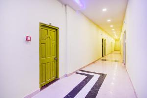 a hallway with green doors and a tiled floor at Super Collection O Howrah Botanical Garden Formerly Tanima Villa in Sāntrāgāchi