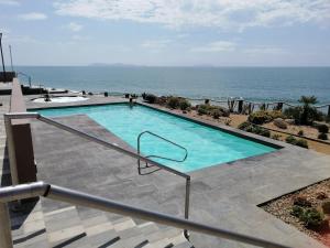 a swimming pool with the ocean in the background at Betty's Apartment in Tijuana +9 photos