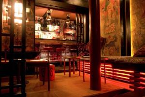 a restaurant with a bar with tables and chairs at Blowhard Lodge Niseko in Kutchan