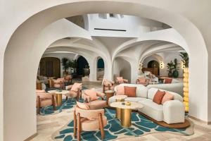 een lobby met stoelen, banken en tafels bij W Sardinia - Poltu Quatu in Porto Cervo