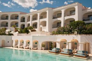 un hotel con piscina frente a un edificio en W Sardinia - Poltu Quatu, en Porto Cervo