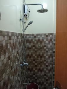 eine Dusche im Bad mit einer gefliesten Wand in der Unterkunft Guyangan Homestay Siargao in Catangnan