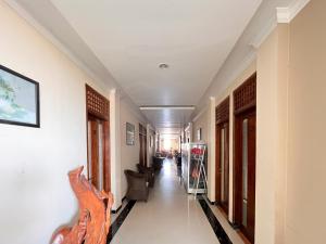 a hallway of a building with chairs and tables at Cozy Bromo Homestay RedPartner in Malang