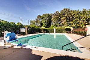 a swimming pool with a blue chair and a chair at Holiday Inn Express - Atlanta-Kennesaw by IHG in Kennesaw