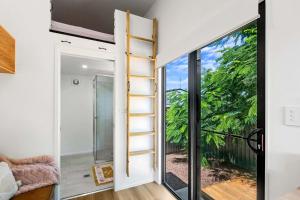 Habitación con escalera junto a una puerta corredera de cristal en Faraway Retreat, en Urangan 1 foto más