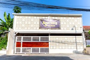 a building with a garage door with a sign on it at Escotel Journey Hotel Antapani in Bandung