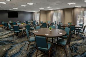 a conference room with tables and chairs and a screen at Fairfield Inn and Suites Atlanta Airport South/Sullivan Road in Atlanta