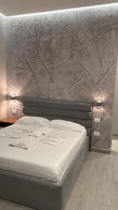 Un dormitorio con una cama grande con una pared. en Hotel Real, en Ishull-Lezhë