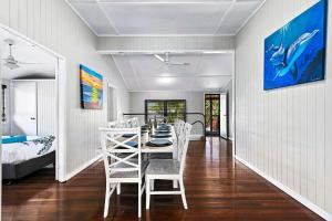 a dining room with a white table and chairs at Large Waterfront Home With Pool in Urangan
