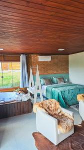 a bedroom with two beds and a bath tub at Chales Vidal in Venda Nova do Imigrante +22 photos