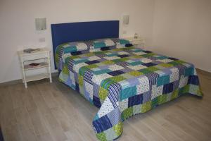 Casa Nova b&b في ألغيرو: غرفة نوم عليها سرير ولحاف