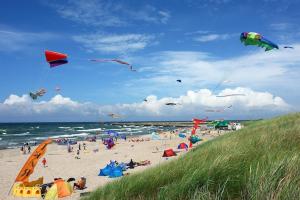 a group of people on a beach flying kites at Cottage in Pobierowo near Baltic Sea in Pobierowo