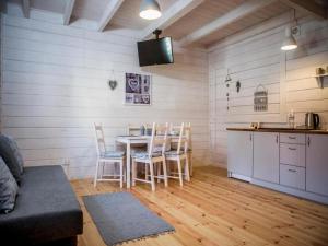 a kitchen and dining room with a table and chairs at Cottage in Pobierowo near Baltic Sea in Pobierowo