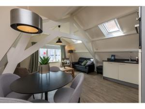Una sala de estar con mesa y sillas y una cocina. en Coastal Apartment in Westkapelle, en Westkapelle
