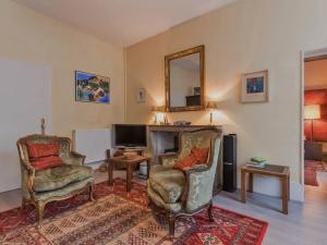 a living room with two chairs and a desk and a mirror at Charmant appartement historique à Vesoul, avec WIFI et parking - FR-1-583-508 in Vesoul