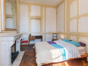 a bedroom with a bed and a fireplace at Appartement charmant au cœur de Vesoul avec parking privé - FR-1-583-509 in Vesoul +14 photos