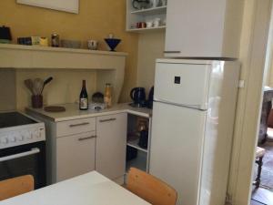 a kitchen with a white refrigerator and a table at Appartement charmant au cœur de Vesoul avec parking privé - FR-1-583-509 in Vesoul