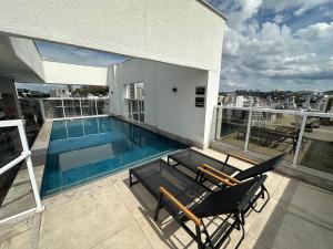 a balcony with a swimming pool on top of a building at Stúdio Royal Central piscina/academia/coworking in Juiz de Fora