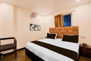 a bedroom with a large bed and a chair at OYO Townhouse Civil Lines Prayagraj Formerly Raj Mahal Palace in Civil Lines