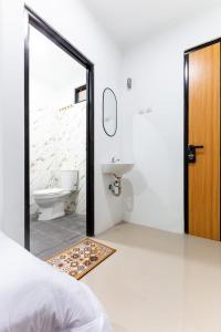 a bathroom with a sink and a toilet and a mirror at Escotel Journey Hotel Antapani in Bandung