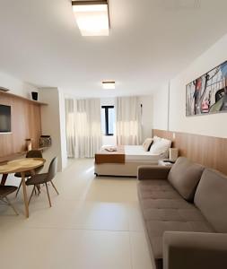 a living room with a couch and a bed at Skylux 702 in Rio de Janeiro