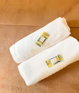 two white towels with gold and blue earrings on them at Skylux 702 in Rio de Janeiro