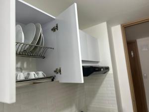 a white cupboard with plates and dishes in it at Apartamento mar in Tunja