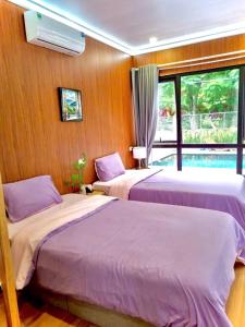 a bedroom with two beds and a window at Sea la vie - Do Son Beach Homestay in Ðố Sơn