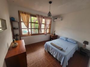 阿约拉港Casa de Muffin的一间卧室,里面有一张床、一张桌子和一扇窗户。