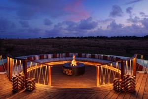 a fire pit on a deck with chairs on it at The Ritz-Carlton, Masai Mara Safari Camp in Masai Mara