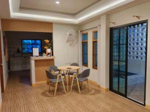 a room with a table and chairs and a kitchen at Minimal Pool Villa Chiang Mai in Chiang Mai