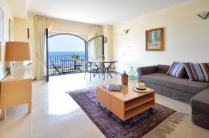 a living room with a couch and a table at Mar dei Poeti - Luxury Suites in Riposto