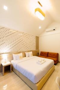 a bedroom with a large bed and a couch at i2 Resort Lampang in Sathani Nakhon Lampang