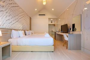 une chambre avec un grand lit blanc et un bureau dans l'établissement i2 Resort Lampang, à Sathani Nakhon Lampang