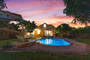 a swimming pool in a yard with a house at Heated Pool Grill Fire Pit & Cold Plunge Sleeps 8! in West Palm Beach