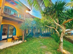 a house with a palm tree in front of it at Flow House 3BR Beachfront An Bang Beach Hoi An by Beachside Boutique Homes in An Bàn (2)
