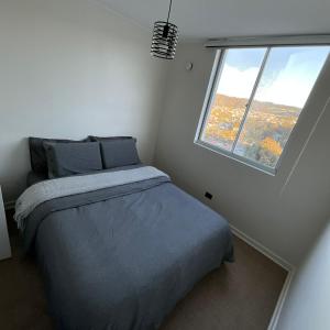 a bedroom with a bed and a large window at Comfort y Estilo in Constitución