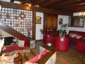 a living room with red furniture and a fireplace at L'Arcouli in Sers