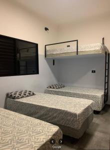two bunk beds in a room with a mirror at Hostel GomaPass Guarulhos Aeroporto in Guarulhos