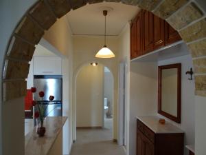 an archway in a kitchen with a sink and a refrigerator at Tassos Village House in Moraitika