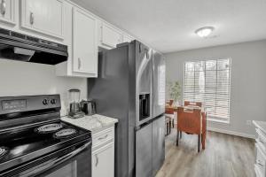 a kitchen with a stainless steel refrigerator and a table at Home Sweet Home Camp Robinson in North Little Rock +6 photos