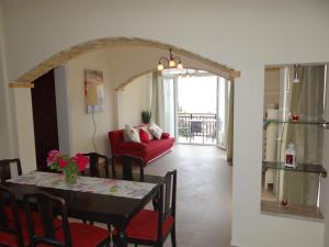 a living room with a table and a red couch at Tassos Village House in Moraitika