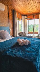 Un dormitorio con una cama azul con almohadas. en Chales Vidal, en Venda Nova do Imigrante